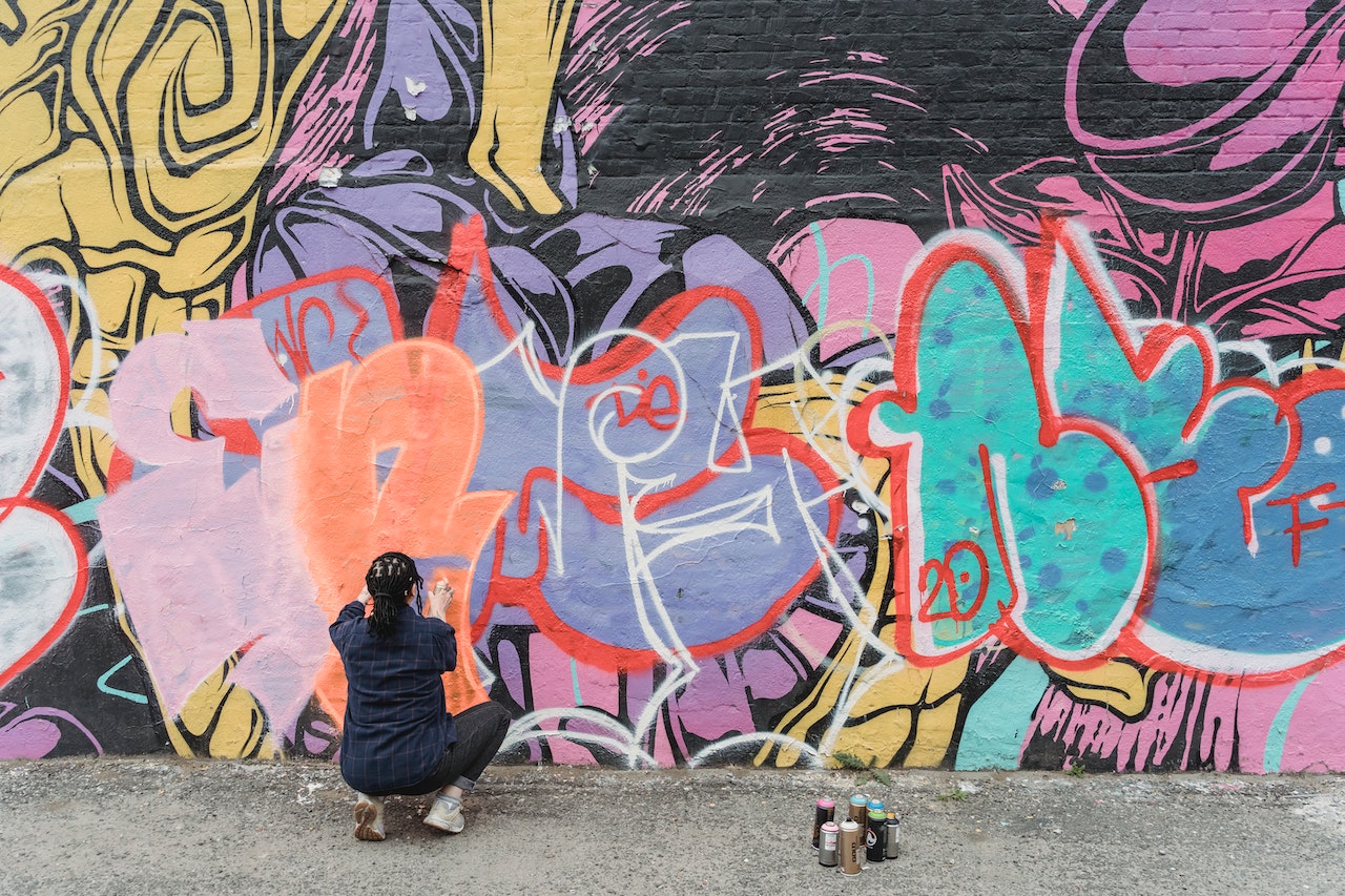 A woman removing graffiti from a wall