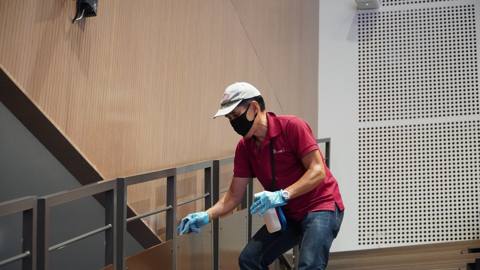 Man cleaning a stair railing outside a building