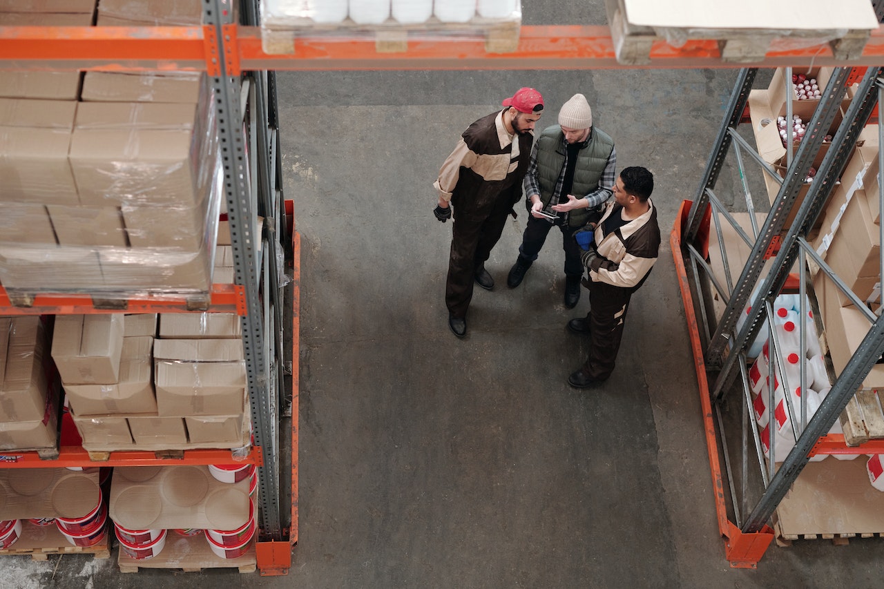 Three men discussing business in a warehouse