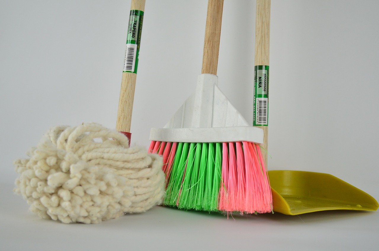A broom with a dustpan and mop