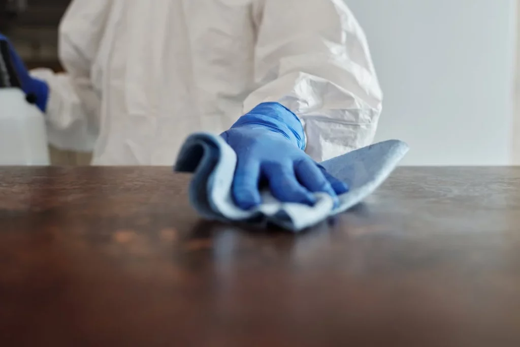 Gloved hand cleaning table