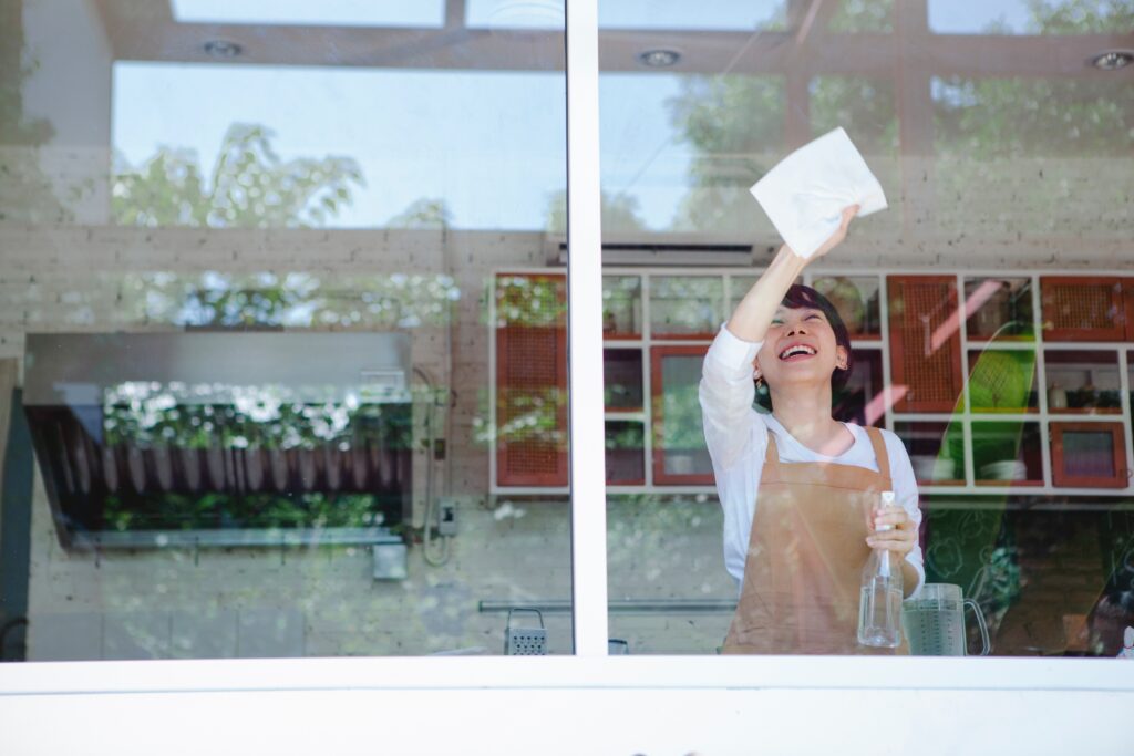 woman-happily-cleaning-window