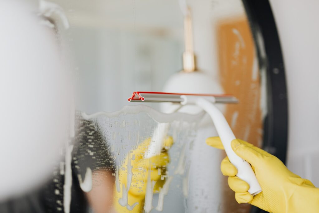 Person cleaning a mirror