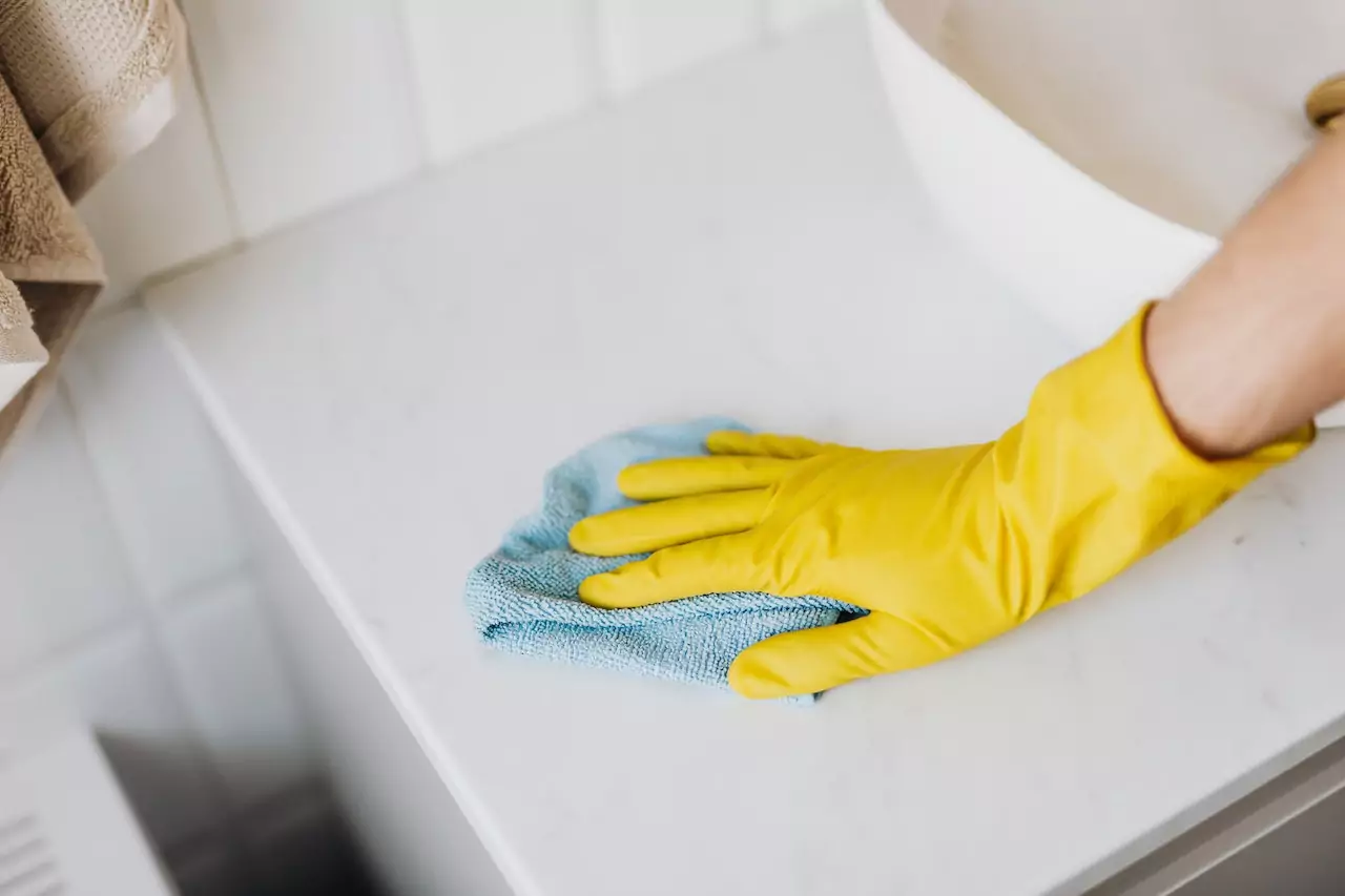 A person cleaning a surface in a bathroom.