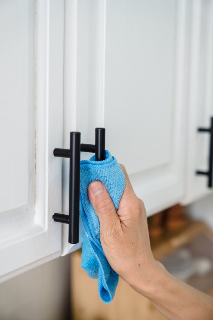 A cabinet handle is being wiped down