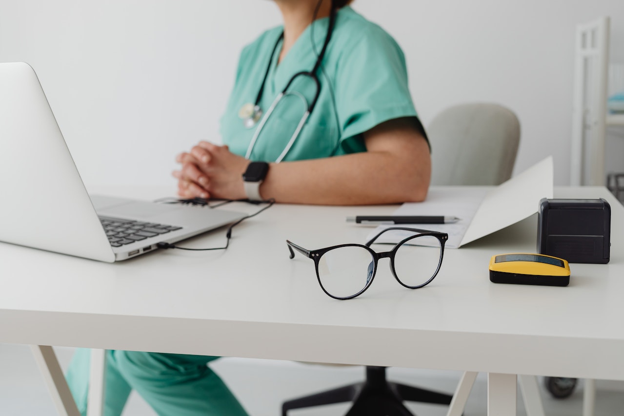 Woman in scrubs using a computer