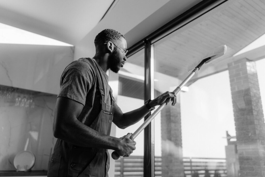 man cleaning high window