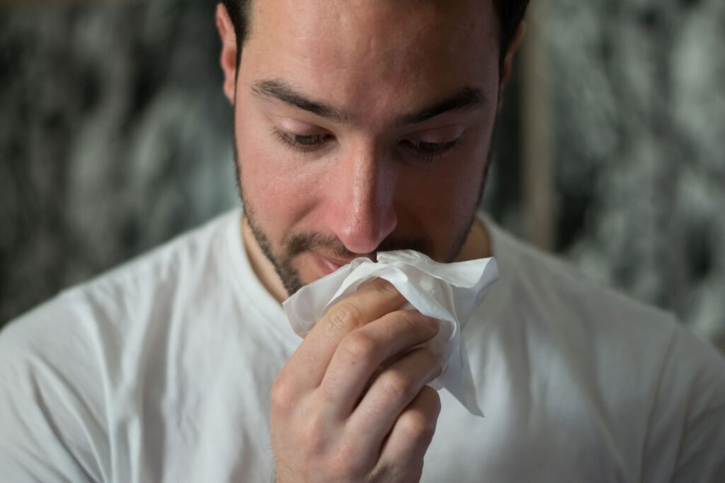 Person holding a tissue to their mouth