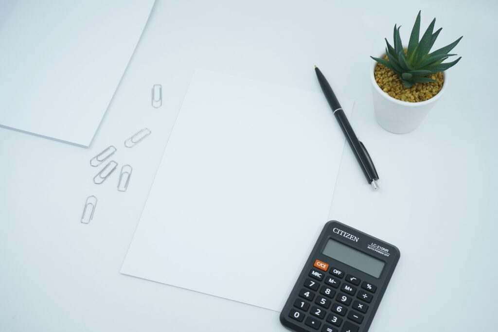 Desk with a calculator, papers and paper clips