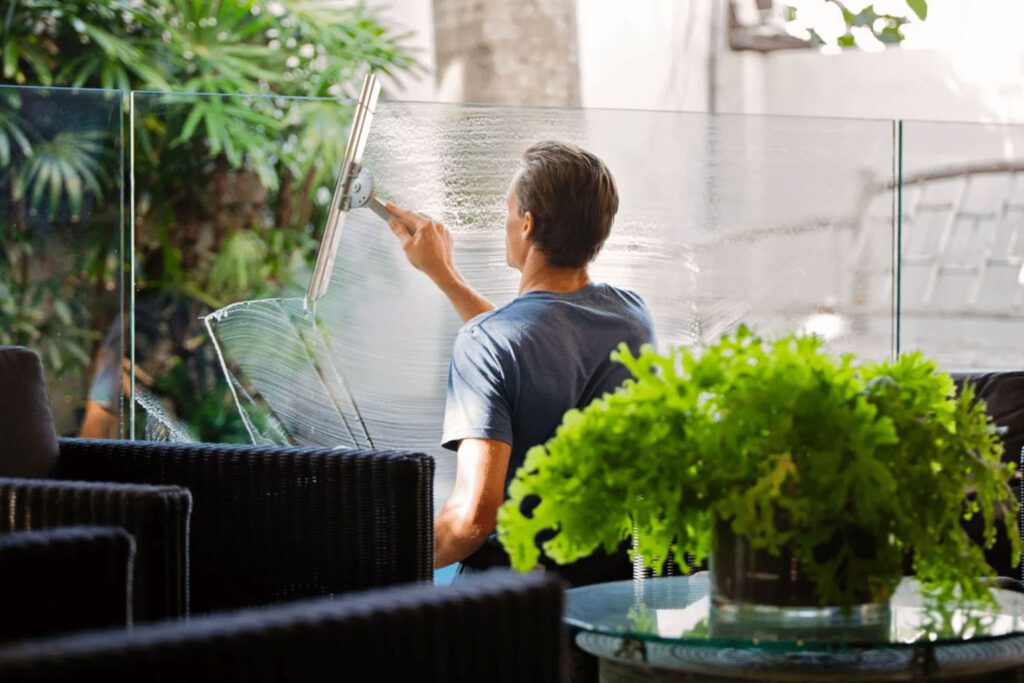 A man cleaning a window in a commercial office