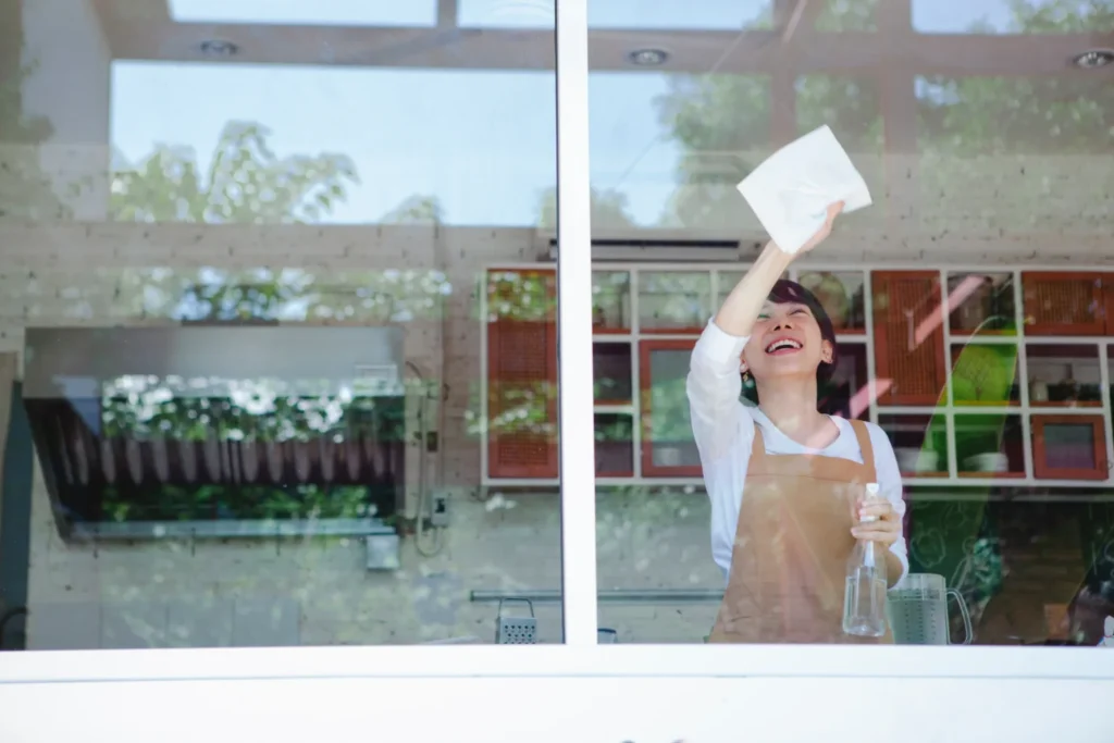 Happy woman cleaning a window