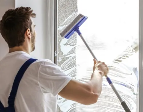 A man cleans the windows of a business