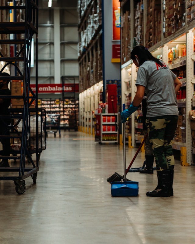 Person sweeping a warehouse