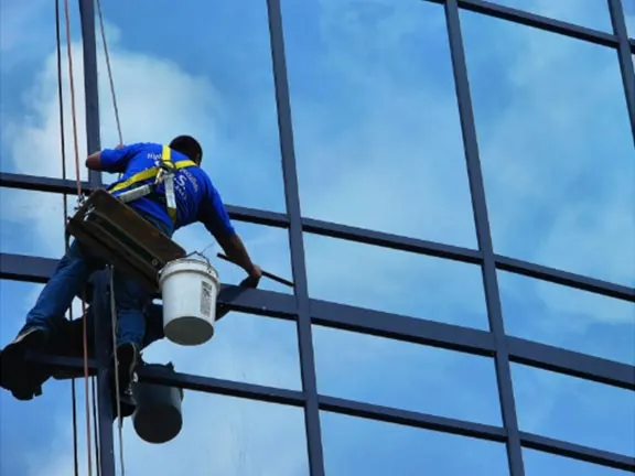 A cleaner washing windows on a commercial high-rise building.