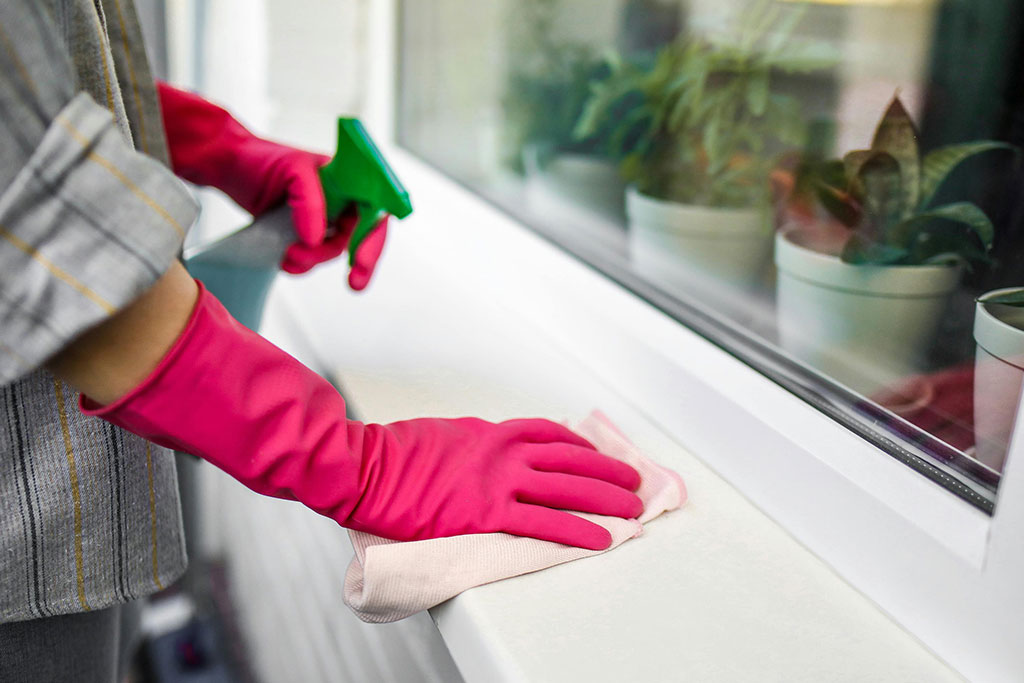 Gloved hands wiping a surface